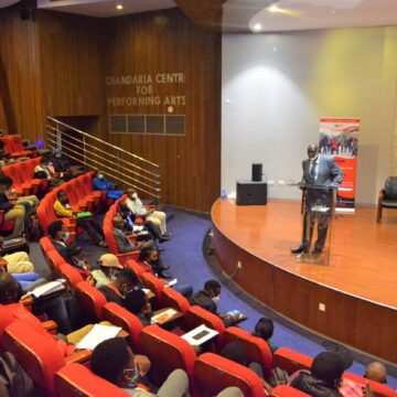 Vice Chancellor's representative giving a speech during the youth conference at the University of Nairobi.